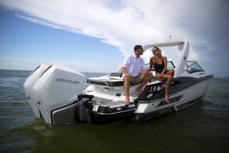 A couple lounging in the back of their Monterey 305 Super Sport as it drifts along the water.