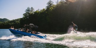 a wakeboarder gets air towing behind and Axis Wake T23